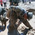 Največja ovira za reševalce je težko prehodno blato. (Foto: Reuters)