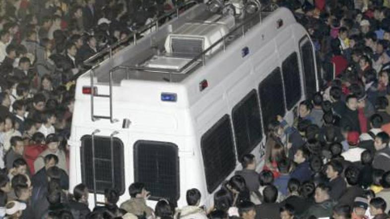 Čakajoči potniki v razstavni hali v mestu Guangzhou, kamor so jih namestili zara