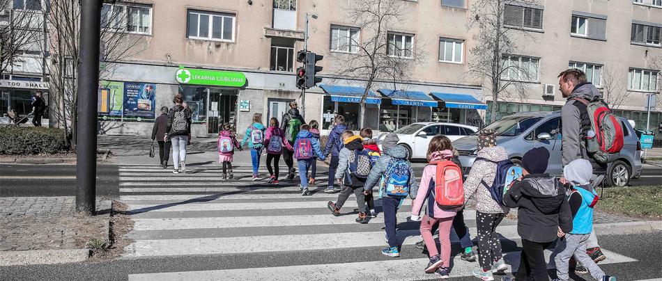 šolski otroci v spremstvu prečkajo cesto