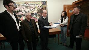 Predstavniki Zveze SABS izročajo predsedniku DZ Cukjatiju peticijo.