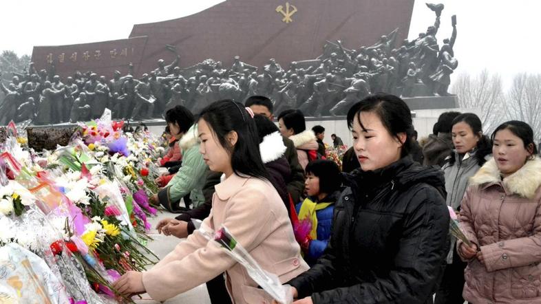 Polaganje svetja pri spomeniku očeta Kim Jong Ila.