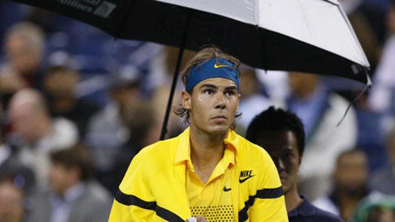 Rafael Nadal je pod varnim zavetjem dežnika po uri in pol zapustil stadion Arthu