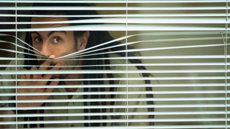 Moški gleda skozi okno