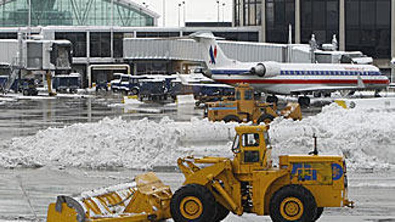Traktorji čistijo sneg na terminalu letališča O'Hare v Chicagu.