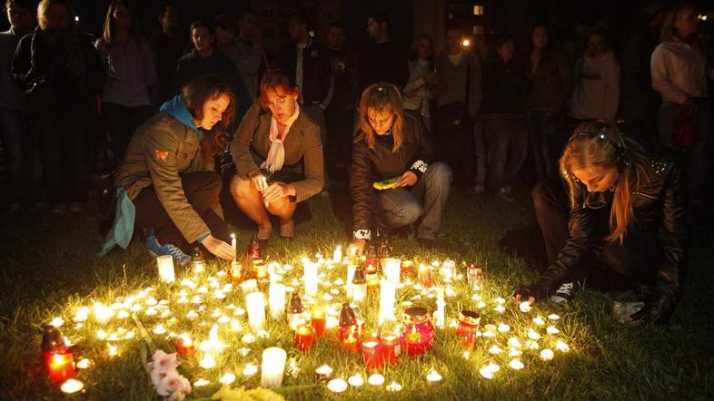 Pretreseni stanovalci so prižigali sveče za žrtve.  (Foto: Reuters)