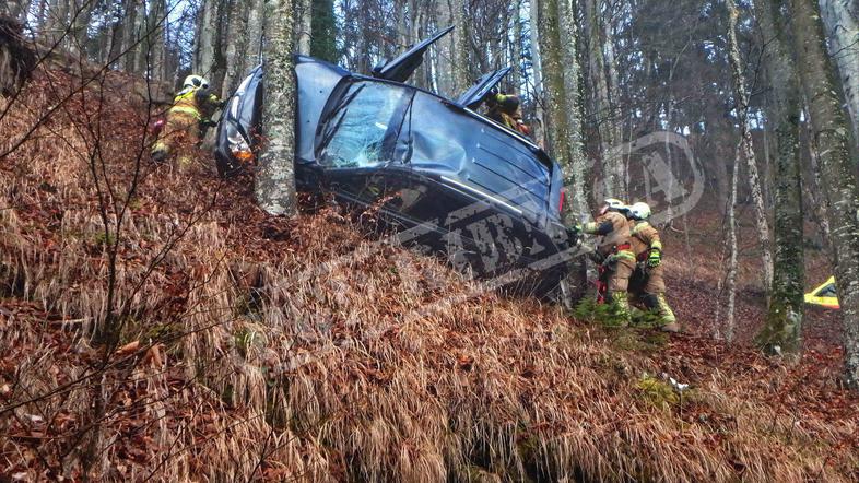 Prometna nesreča, avto zagozden med drevesi
