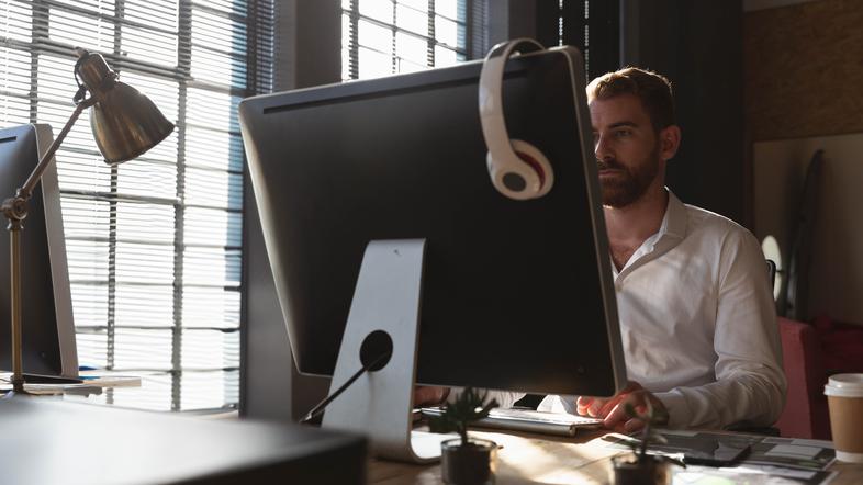 Moški sedi za računalnikom