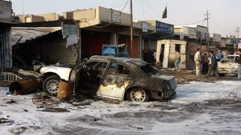 A burnt vehicle is seen after a bomb attack took place in Baghdad's Bayaa distri