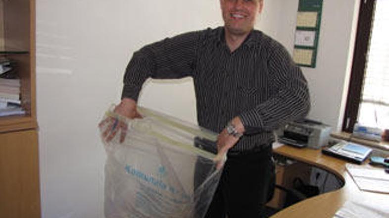 Vodja poslovne enote komunale Primož Bajželj z novo ekološko vrečko, ki pomeni z