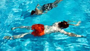 otroka plavata v bazenu