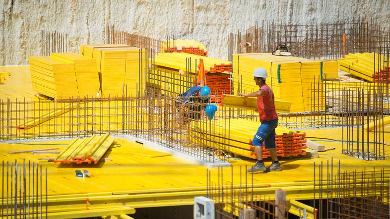 Gradbeni delavci med delom na žgočem soncu.