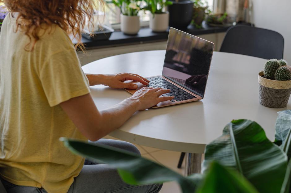 Ženska sedi za mizo in dela od doma za računalnikom | Avtor: Profimedia