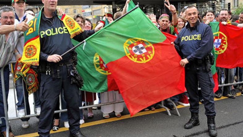 Švicarski policisti pozirajo s portugalskimi navijači.