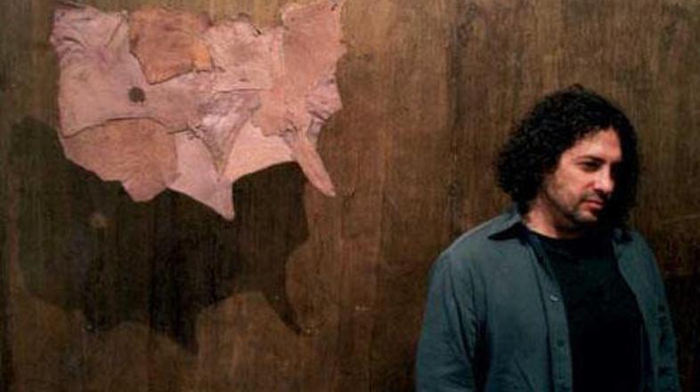 Andrew Krasnow pred zemljevidom ZDA, narejenim iz človeške kože.