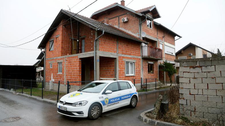 policijski avtomobil pred hišo v Brčkem, v kateri so našli 31 otrok