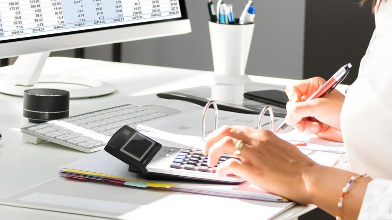 Ženska s kalkulatorjem za račznalnikom