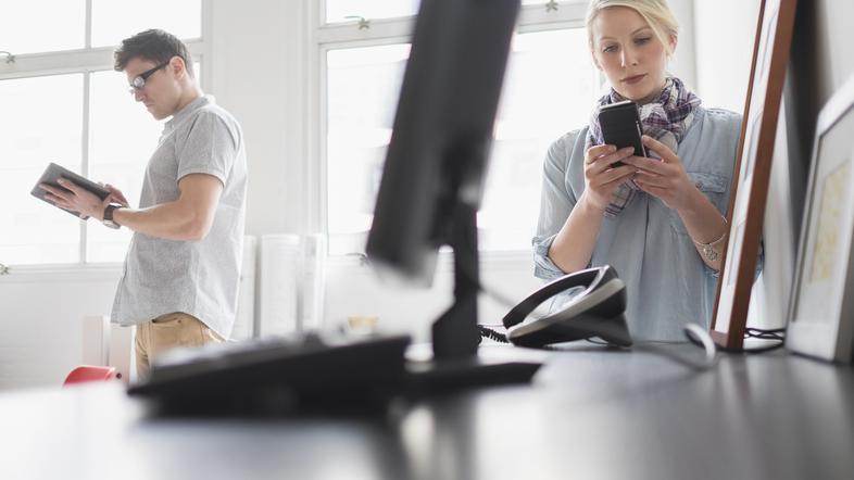 Ženska s telefonom in moški v pisarni