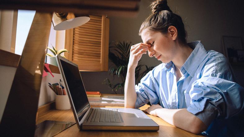 Utrujena ženska pred računalnikom
