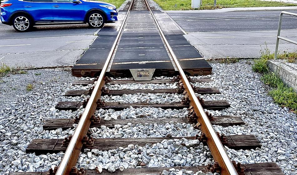 Kolesar zapeljal mimo čakajočih vozil, ko je pripeljal vlak