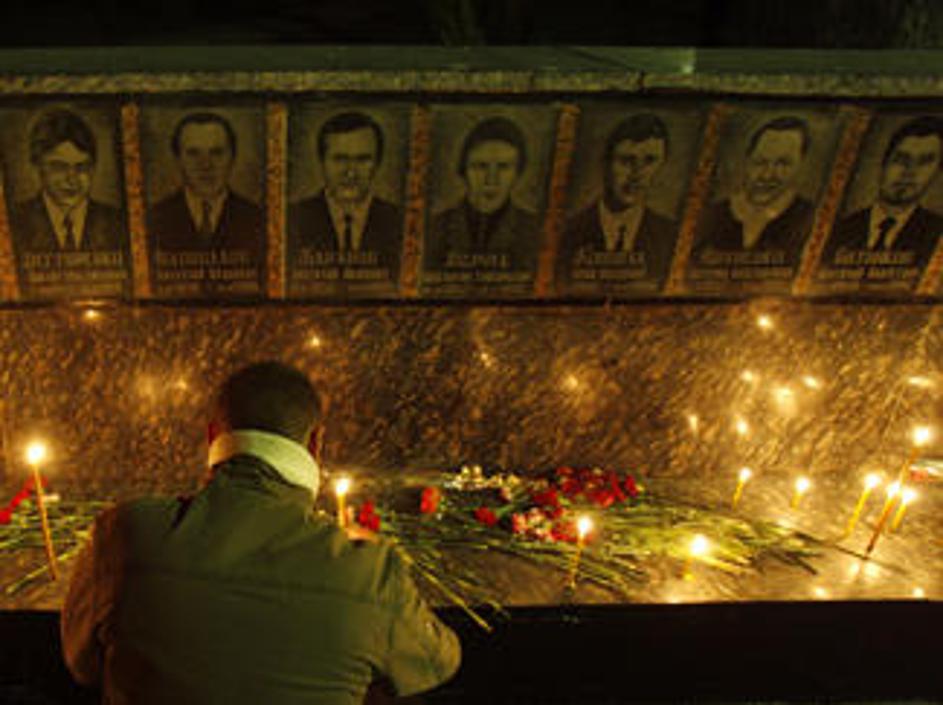 Moški prižiga sveče za gasilce, ki so izgubili življenje ob gasenju reaktorja.