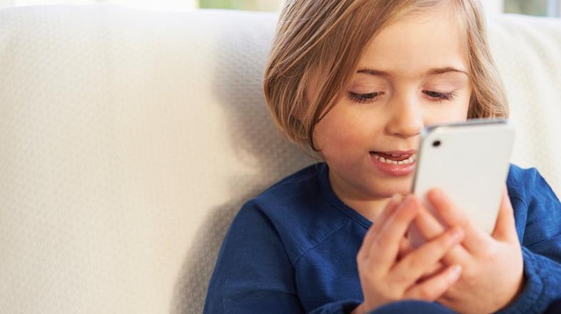 Otrok z mobilnim telefonom