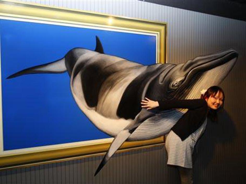 Obiskovalka muzeja pozira pred zanimivo sliko.