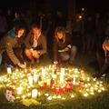 Pretreseni stanovalci so prižigali sveče za žrtve.  (Foto: Reuters)