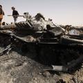 Uporniki pregledujejo od zavezniških letal uničeni tank pri Adžabiji. (Foto: Reu