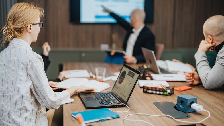 Sodelavci v pisarni med predstavitvijo