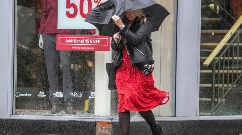 dež veter dežnik ženska na ulici