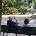starejši moški in ženska sedita na klopi v senci vročinski val