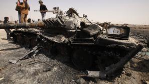 Uporniki pregledujejo od zavezniških letal uničeni tank pri Adžabiji. (Foto: Reu