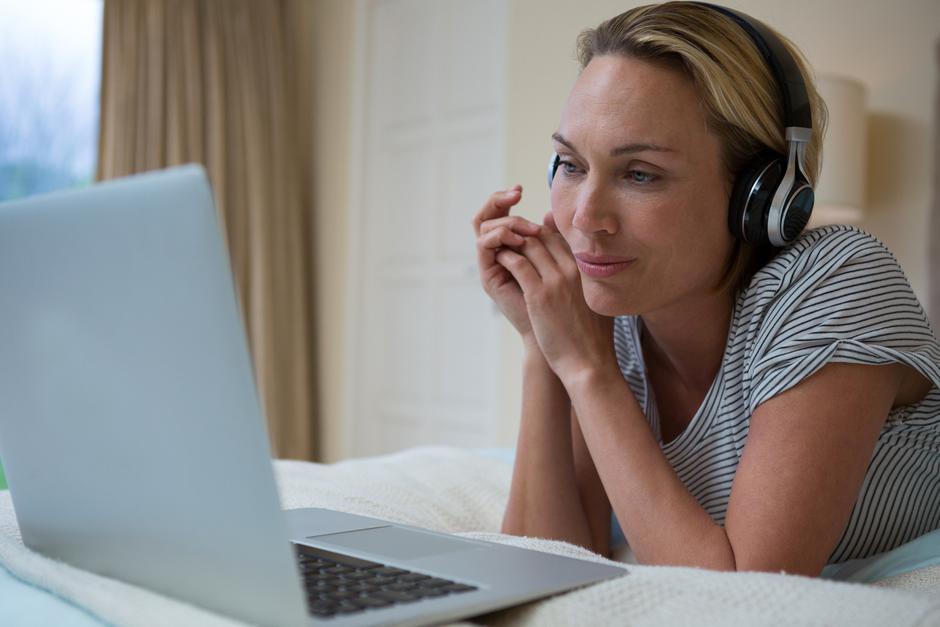 Ženska slušalke postelja računalnik | Avtor: Profimedia