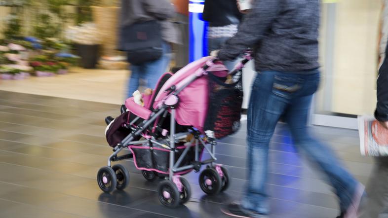 moški potiska pred seboj voziček