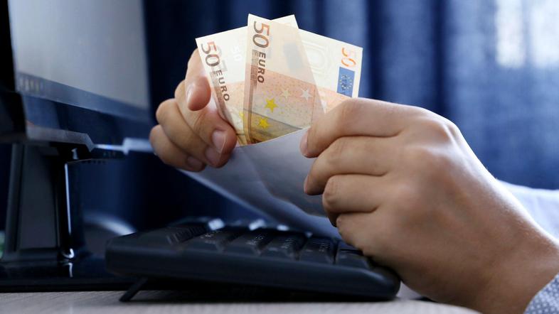 moški vleče evrska bankovca iz kuverte