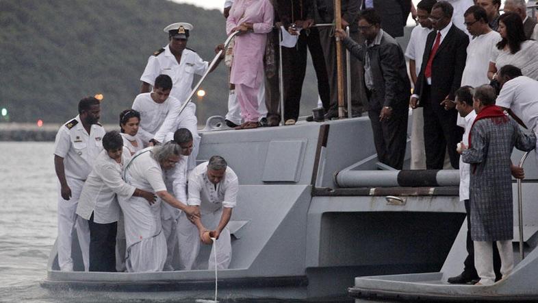 V morje so poleg pepela vrgli tudi cvetje in sveče. (Foto: Reuters)