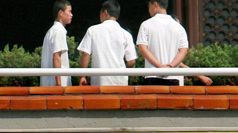 Kitajska policista v civilu nadzorujeta mimoidoče.