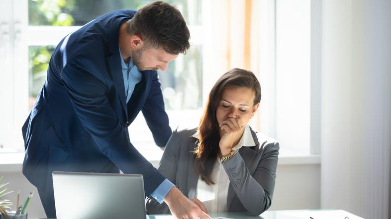 moški in ženska v pisarni zaskrbljeno gledata dokumente