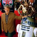 Ustvarjalec Vojne zvezd George Lucas (L) pozira skupaj z junakoma sage R2D2 in C