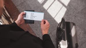 moški drži v rokah letalsko karto