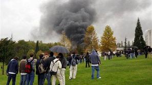 Študenti gledajo oblak dima, ki se vije nad univerzitetnim središčem v Pamploni.