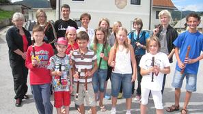 Udeleženci letošnje poletne šole za kljunasto flavto z mentorji pred domom za le