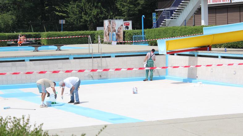 Na dan odprtja kopalne sezone so delavci še popravljali dno srednjega bazena, si