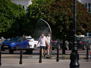 moški se hladi pod vodno meglica vročinski val na Poljskem