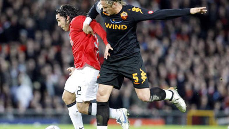 Carlos Tevez in Philippe Mexes v boju za žogo na Old Traffordu.
