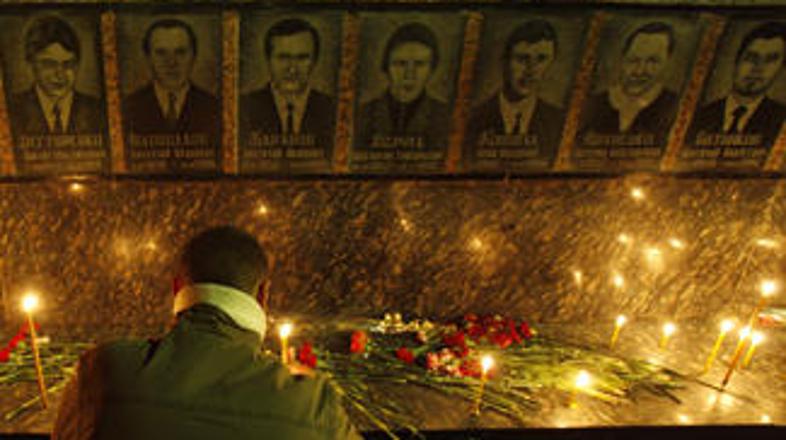 Moški prižiga sveče za gasilce, ki so izgubili življenje ob gasenju reaktorja.