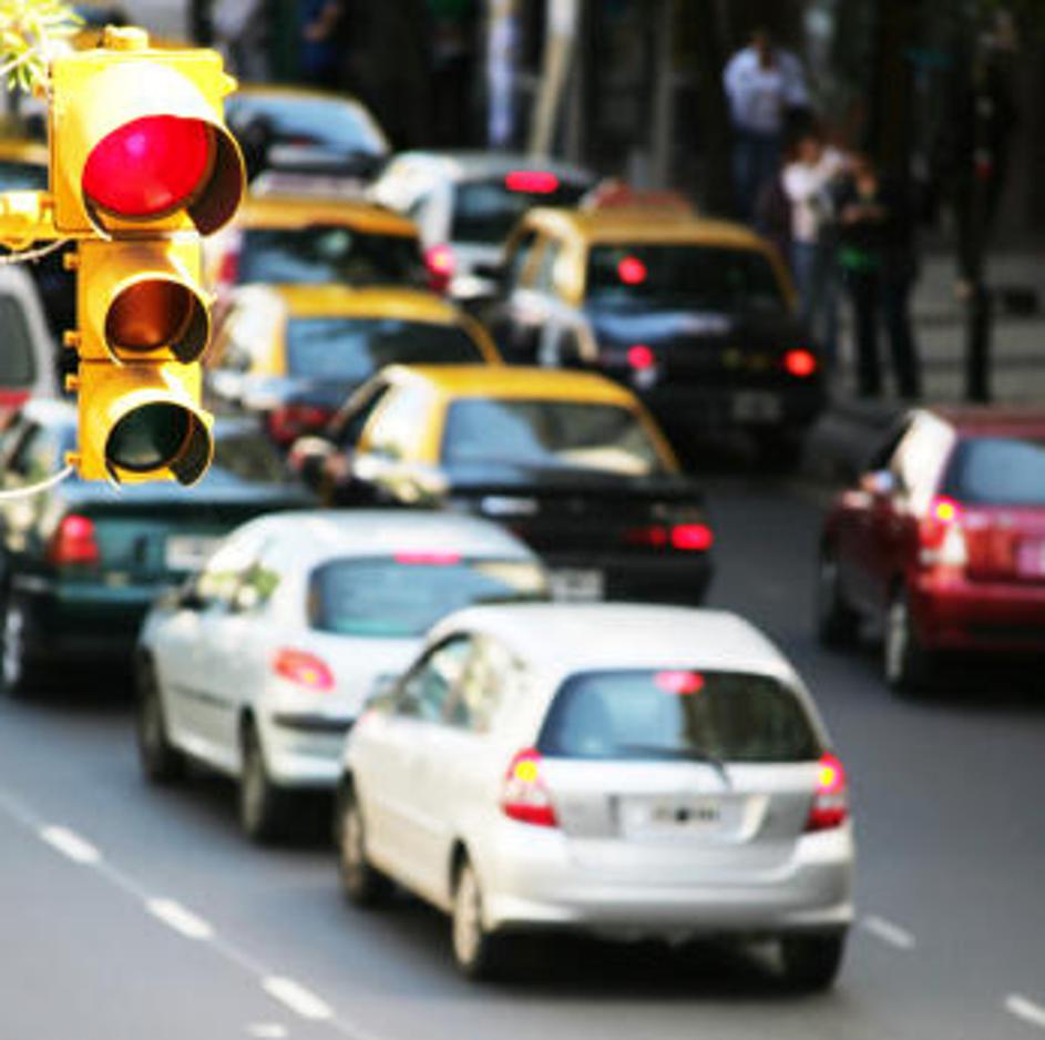 Policist, ki ni na nujni vožnji, pred vašim avtomobilom zapelje v rdečo luč. Mu 