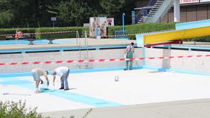 Na dan odprtja kopalne sezone so delavci še popravljali dno srednjega bazena, si