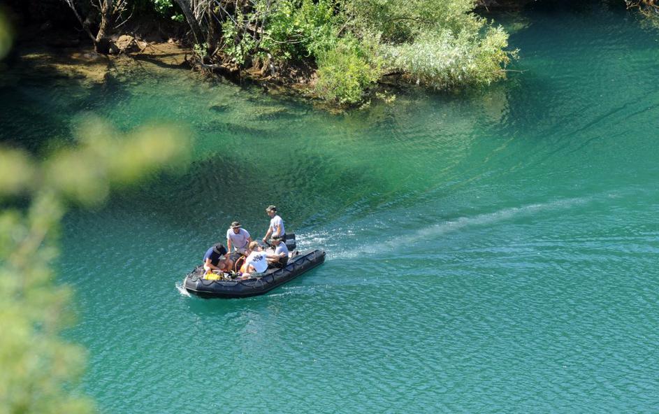 Slovenski vojaki in policist z radarjem preiskujejo jezero.