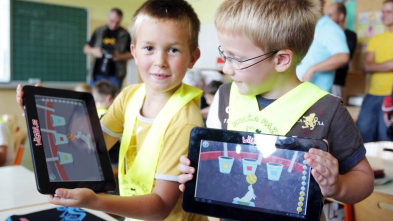 Otroci s tablicami v rokah.